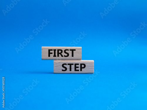 First step symbol. Wooden blocks with words 'First step'. Beautiful blue background. Business and 'First step' concept. Copy space.