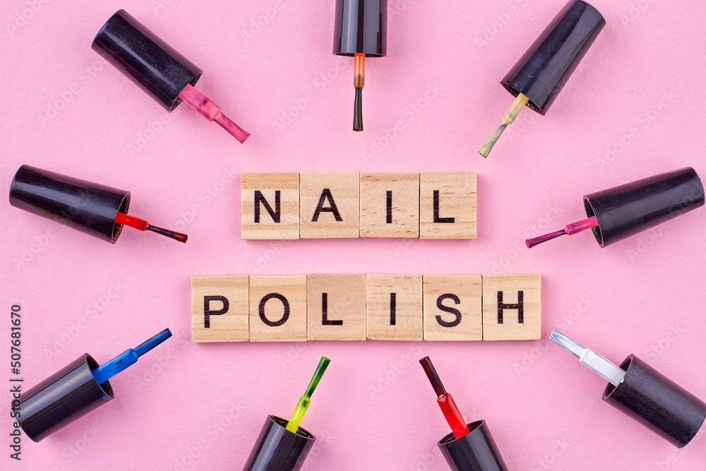 Various nail polishes background. Wooden cubes with inscription nail polish. Makeup and beauty concept. Various nail polishes background. Wooden cubes with inscription nail polish. Makeup and beauty concept.
