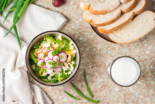 Chopped ingredients for okroshka in a bowl on the table. Top view photo