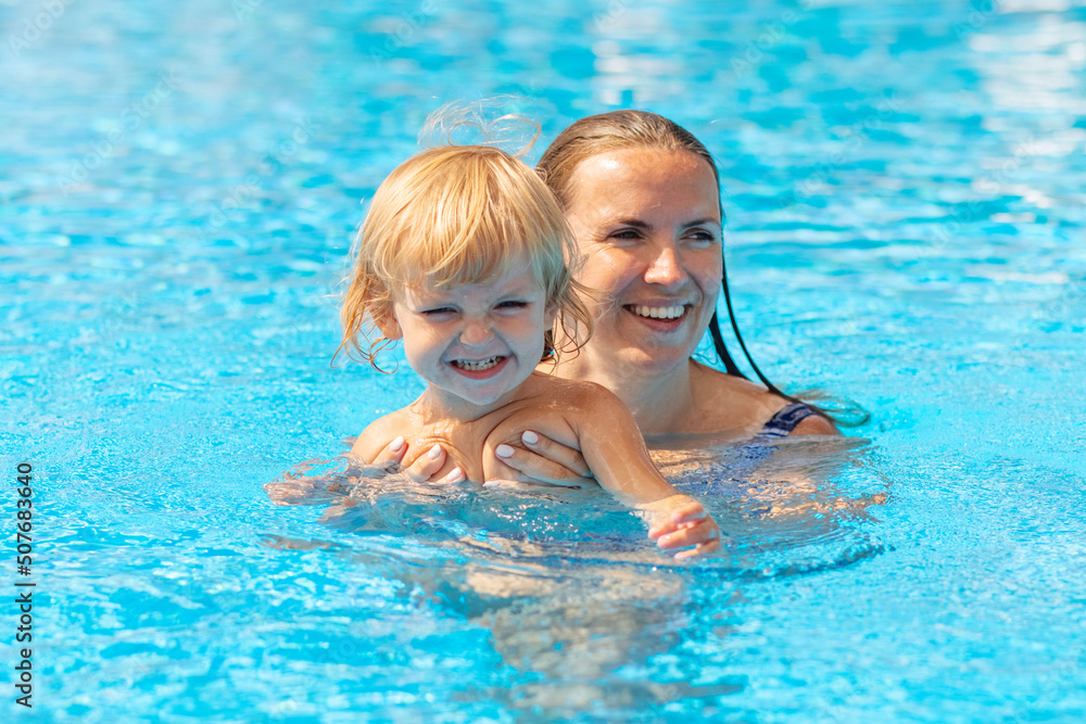 Mother with her son having fun in the swimming pool. Classes for babies. Family time