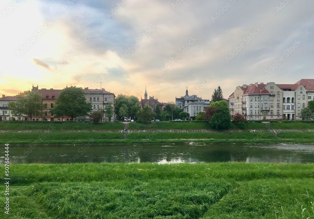 San river embankment, Przemysl, Poland. In summer it is very nice to walk on it among the flowering bushes and in the shade of green trees above the old houses.