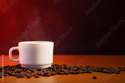 Coffee cup with smoke and freshly roasted coffee beans with copy space