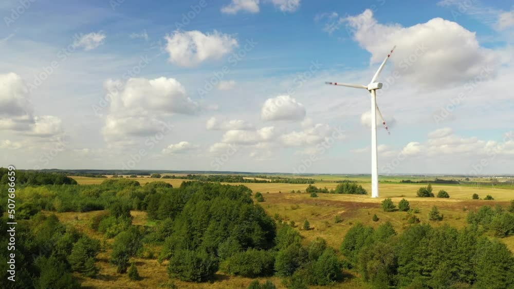 A windmill generates electricity against a background of blue sky and white clouds A windmill generates electricity against a background of blue sky and white clouds