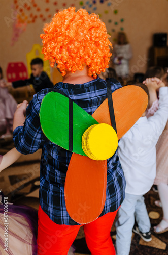 A children's animator in a carlson costume with a propeller indoors entertains children in a kindergarten at a birthday party. photo