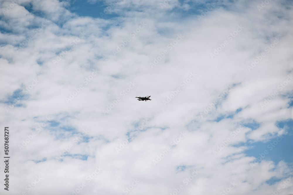 A large military supersonic fighter jet flies in the sky.