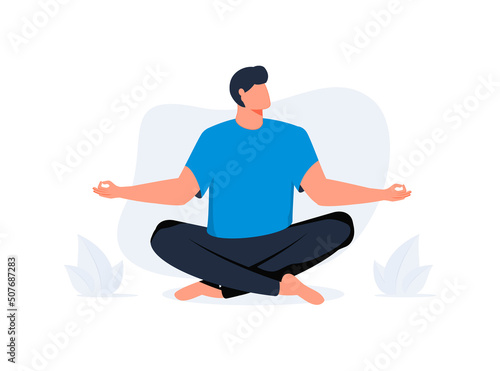 Young man doing yoga, sits with cross-legged on the floor and meditates with closed eyes. Boy makes morning yoga relaxes