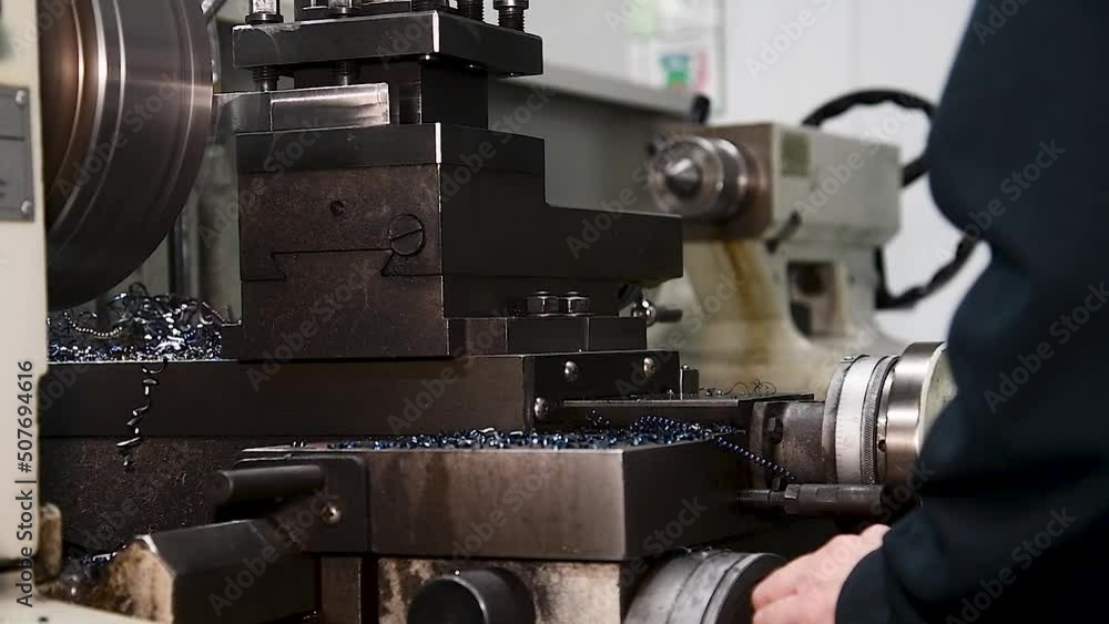 Heavy industrial worker performs a mechanical operation on a machine for the production of steel structures Heavy industrial worker performs a mechanical operation on a machine for the production of steel structures