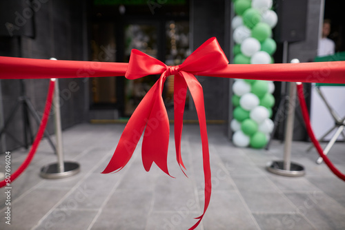 Red ribbon bow at the store opening. Event. photo