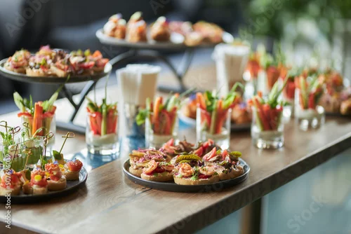 Obraz Lots of good food on the table. Small sandwiches on a black plate. Catering