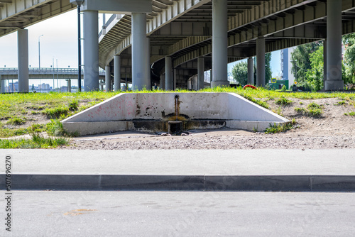 Fotografie A source of clean water in the city near the roadway under the automobile bridge
