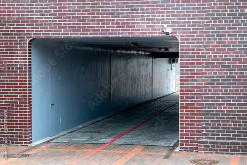 The entrance to the tunnel is tiled in the form of brickwork with an installed surveillance camera.