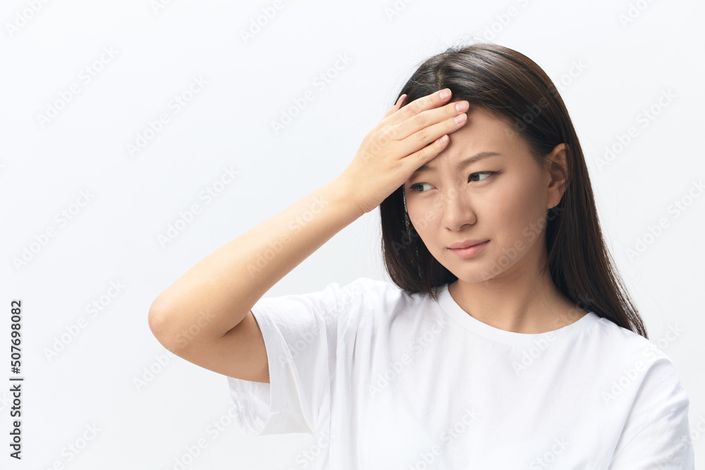 Migraine. Side view of unhappy suffering from headache tanned beautiful young Asian woman touching forehead posing isolated on white background. Injuries Poor health Illness concept. Cool offer Banner Migraine. Side view of unhappy suffering from headache tanned beautiful young Asian woman touching forehead posing isolated on white background. Injuries Poor health Illness concept. Cool offer Banner