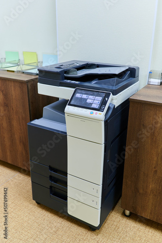 copier for printing stands in the interior of the office space photo
