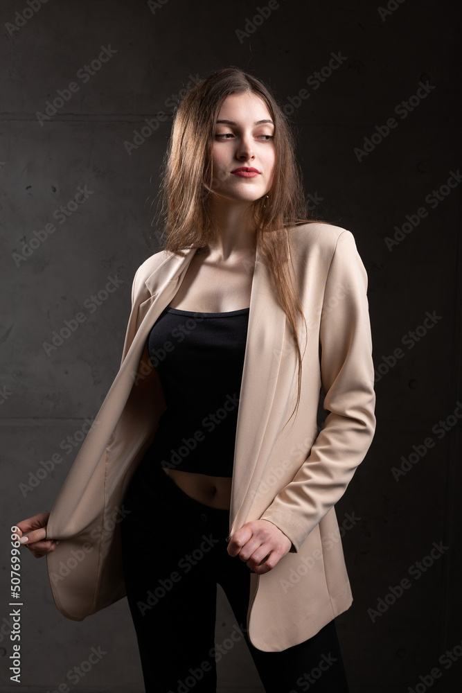 Portrait of a young brunette with long hair in the studio. Dramatic photo in dark colors. Portrait of a young brunette with long hair in the studio. Dramatic photo in dark colors.