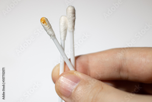 hand holding dirty and clean cotton buds