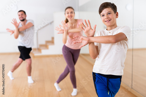 Young boy exercising aerobic dance with her family in gym.