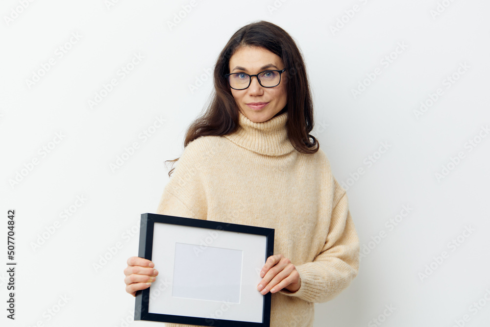 a beautiful, sweet, attractive woman in black glasses for vision, with long dark hair, with empty white frame in her hands. Studio photography with space for advertising mockup a beautiful, sweet, attractive woman in black glasses for vision, with long dark hair, with empty white frame in her hands. Studio photography with space for advertising mockup