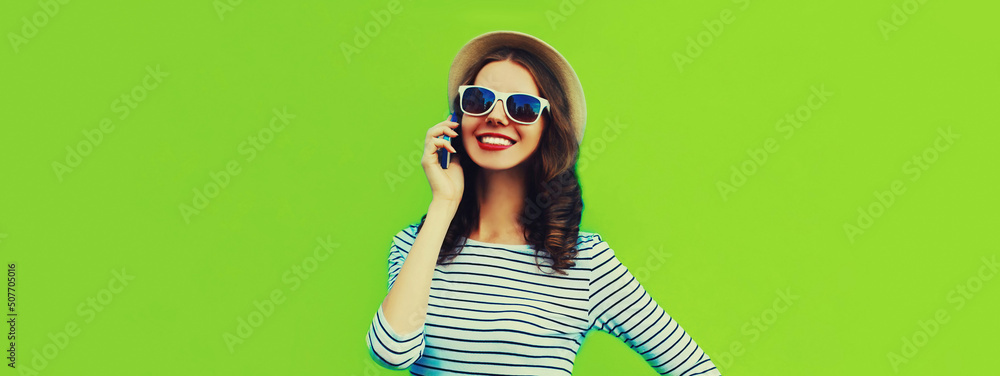 Portrait of happy smiling young woman calling on smartphone on green background, blank copy space for advertising text