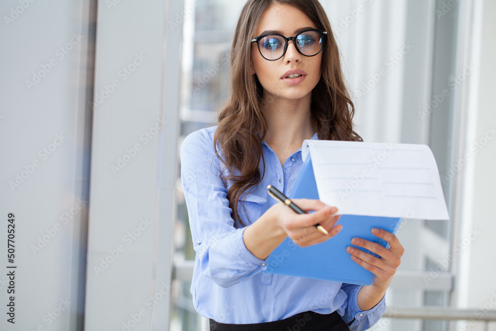 Portrait business woman in modern office looking at camera. Portrait business woman in modern office looking at camera.