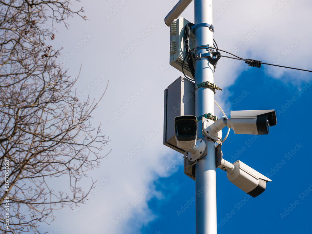 View of a contemporary surveillance CCTV cam attached to metal pole. View of a contemporary surveillance CCTV cam attached to metal pole.