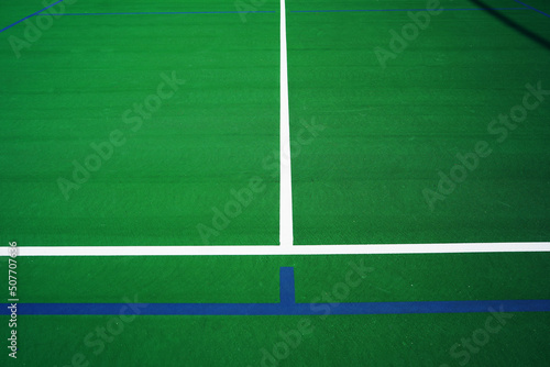 A Tennis Court has been marked off with blue tape for pickleball.     