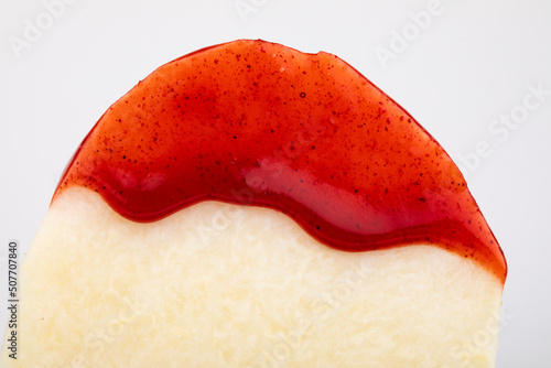 A slice of jicama covered with chamoy sauce. photo