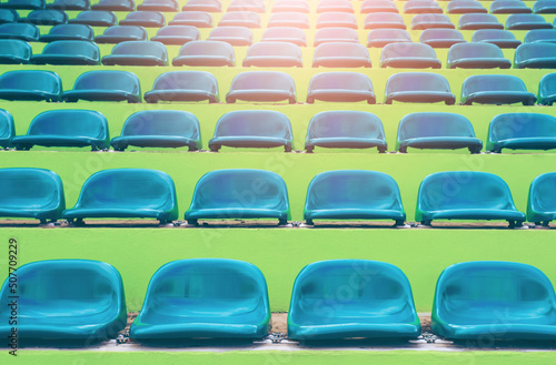 A row of green plastic chairs on the grandstand, football field mall.green background