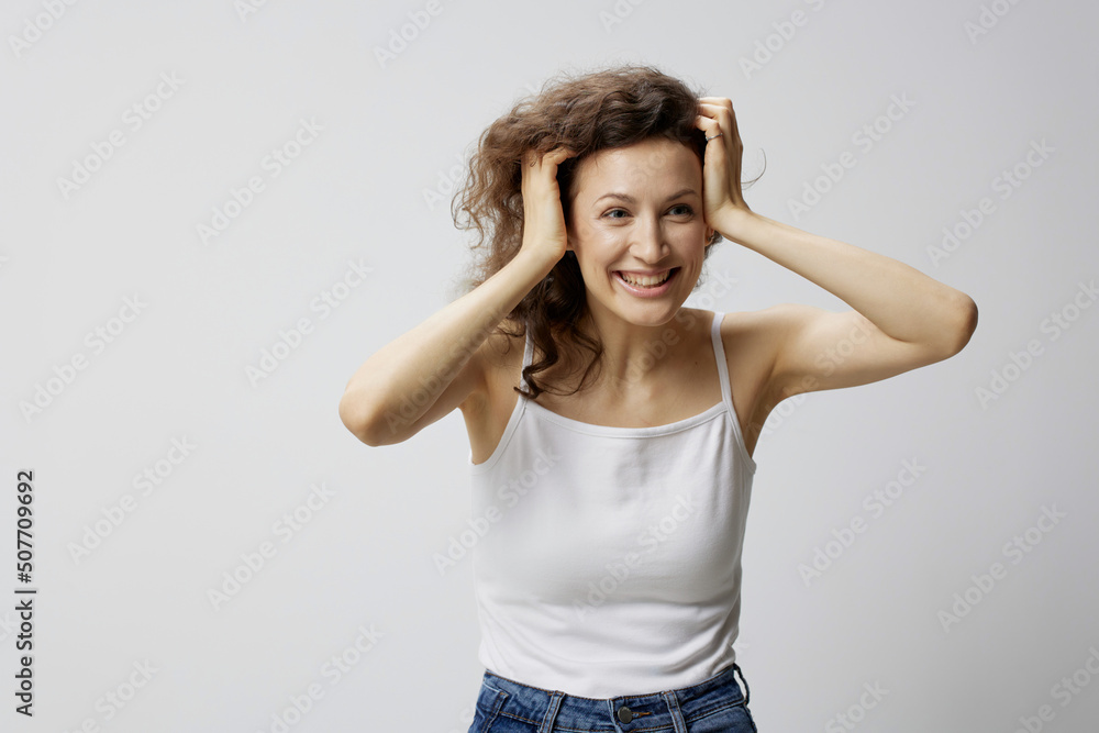 Surprised excited shocked curly beautiful woman in basic white t-shirt touches head open mouth posing isolated on white background. People Emotions Lifestyle. I cant believe it concept. Copy space Surprised excited shocked curly beautiful woman in basic white t-shirt touches head open mouth posing isolated on white background. People Emotions Lifestyle. I cant believe it concept. Copy space