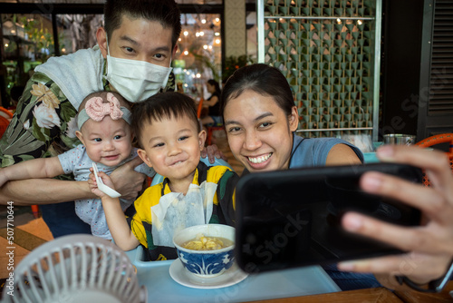 A happy Thai family selfie in the restaurant in Thailand.