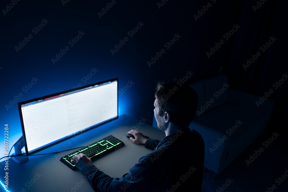 male worker doing job on computer late in the night at home male worker doing job on computer late in the night at home