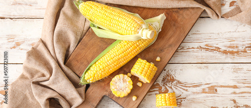Photos Board with fresh corn cobs on wooden table