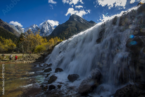 Wenzhou Waterfall in Aba, Sichuan Province, with yellow leaves, Zhuoma Lake, distant mountains and white clouds photo