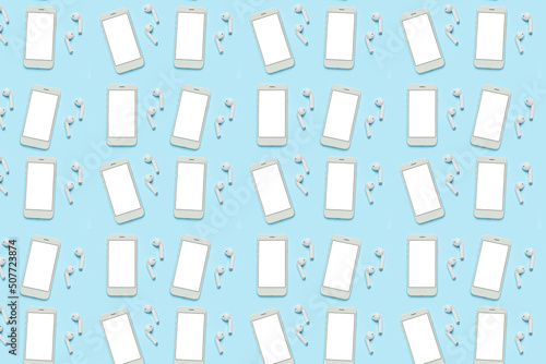 Many smartphones with blank screens and earphones on light blue background. Pattern for design