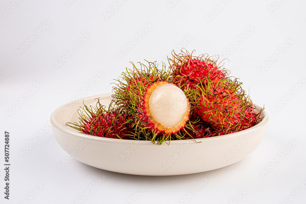 Rambutan fruit on ceramic white plate on white table background. Rambutan fruit on ceramic white plate on white table background.