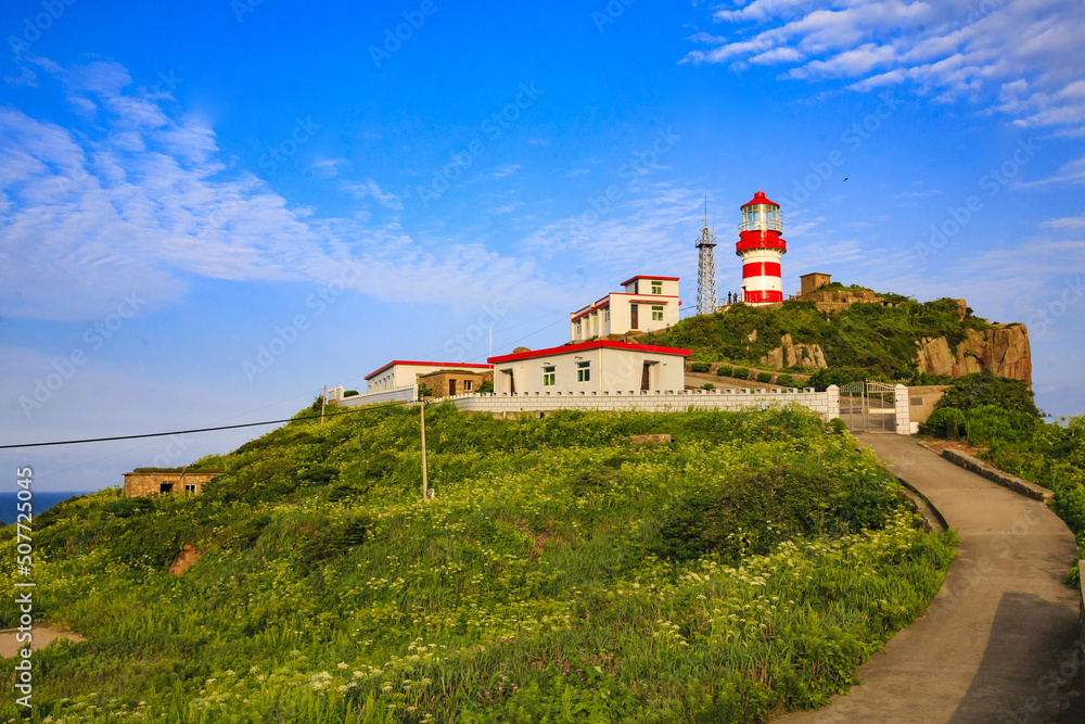 The lighthouse on the sea under blue sky The lighthouse on the sea under blue sky