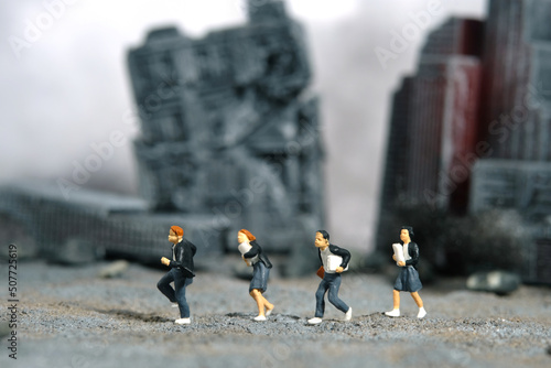 Miniature people toy figure photography. School education for students in conflict areas concept. Pupils running on ruined demolished city diorama background