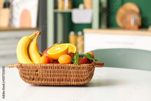 Obraz na plátně Wicker fruit basket on table in dining room