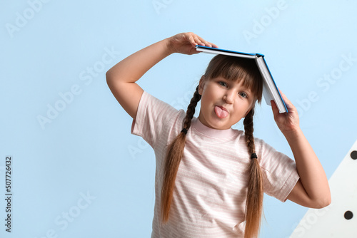 Little girl with book showi...