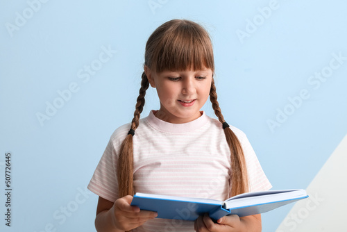 Little girl reading book on...