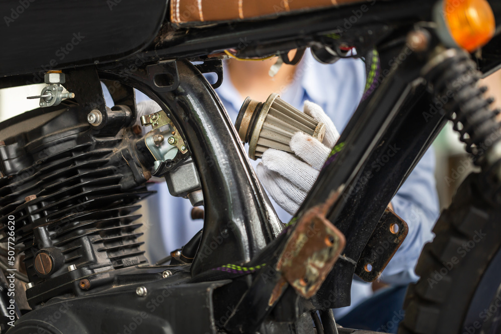 Man checking air filter, Mechanic repairing motorcycle in repair shop, Man repair motorbike in garage, mechanic fixing motorcycle engine