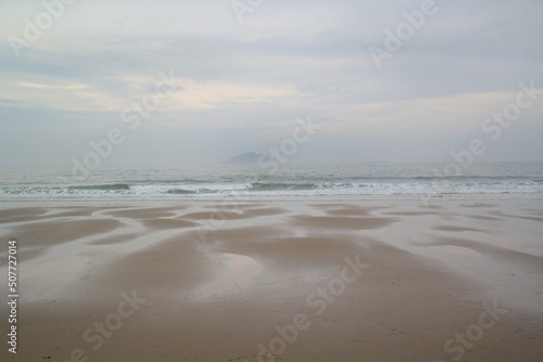 There is a waterway on the beach after the tide has receded.