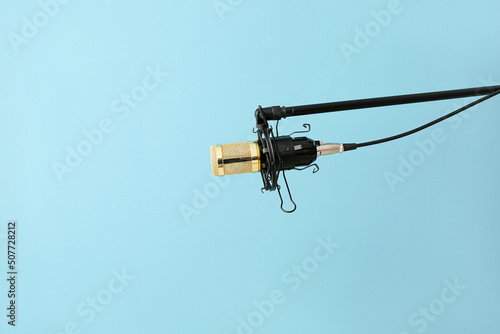 Stand with professional microphone on color background