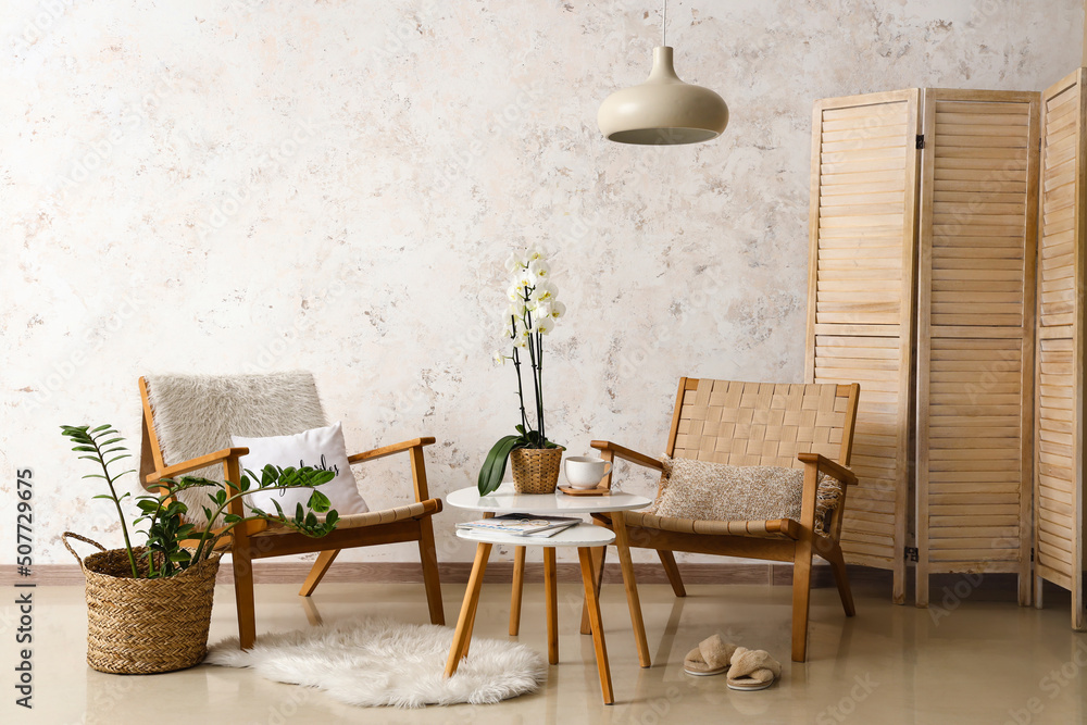 Interior of room with armchairs and table near light wall - obrazy, fototapety, plakaty 