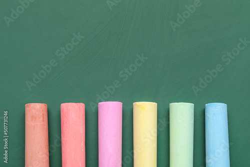 Colorful chalks on green blackboard