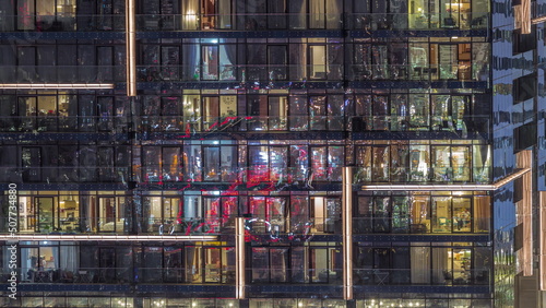 Flat night panorama of multicolor light in windows of multistory buildings aerial timelapse.