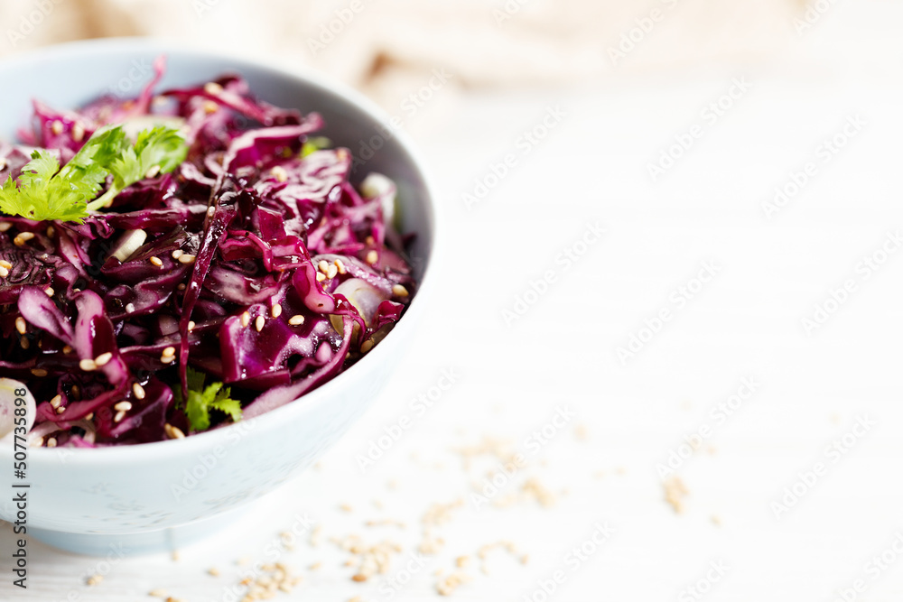 red cabbage salad, coleslaw, in a bowl on white wooden table. red cabbage salad, coleslaw, in a bowl on white wooden table.