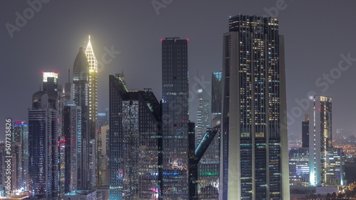 Photography Close up view of Dubai Financial Center district with tall skyscrapers illuminated at night timelapse