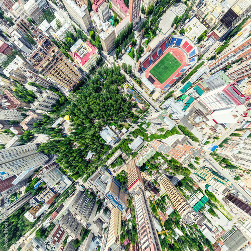 Aerial city view with crossroads and roads  houses  buildings  parks and parking lots  bridges. Helicopter drone shot. Wide Panoramic image.