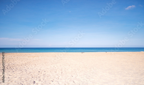 Tropical sandy beach with blue ocean and blue sky background image for nature background or summer background