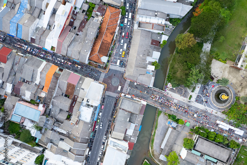 Aerial view Drone flying over phuket city Thailand.Drone over a street night market in Sunday at Phuket Town and Tourists walking shopping at old street full of local vendors selling Food and Clothes